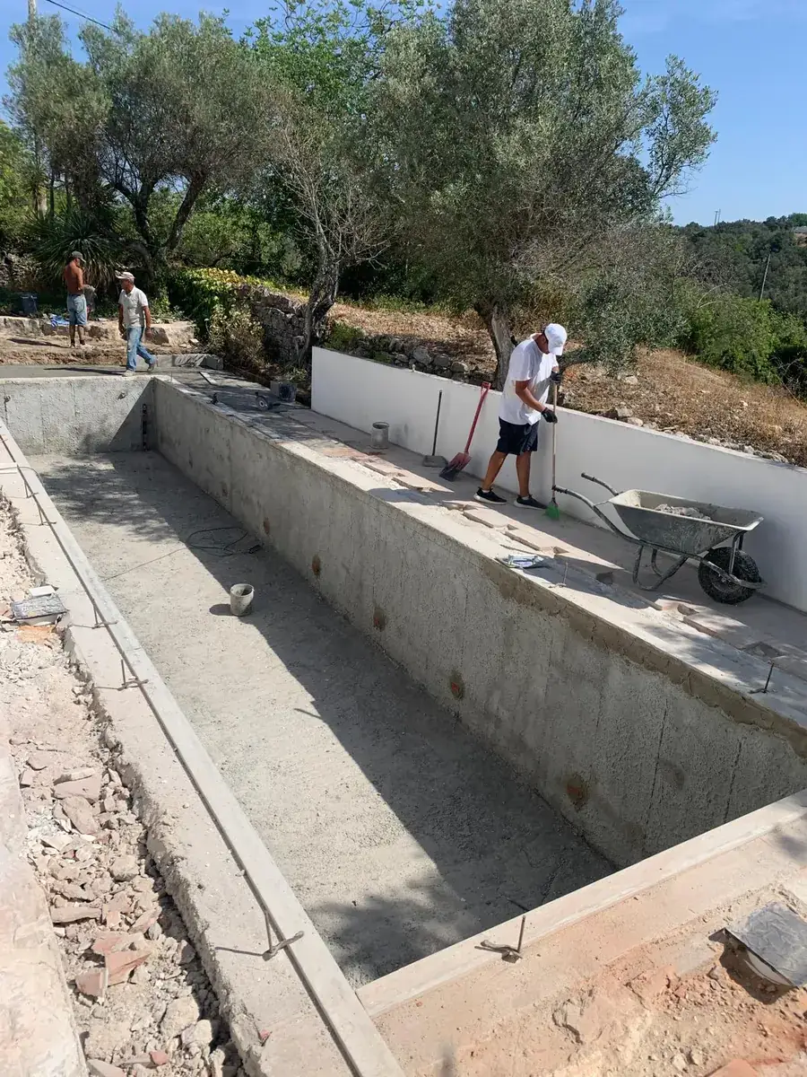 The same pool during excavation, with the concrete shell being formed among olive trees